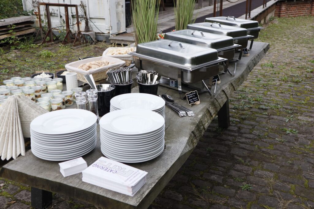 Klein Catering Speisenangebot Ein professionell angerichtetes Buffet von Klein Catering mit Warmhaltebehältern, Geschirr und Gläsern, perfekt vorbereitet für Events im Kreis Herford